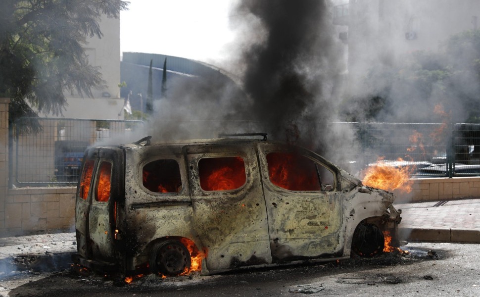 epa10904808 A burning vehicle in the Israeli city of Ashkelon following rocket launches from Gaza, 07 October 2023. Rocket barrages were launched from the Gaza Strip early Saturday in a surprise attack claimed by the Islamist movement Hamas.  EPA/ATEF SAF