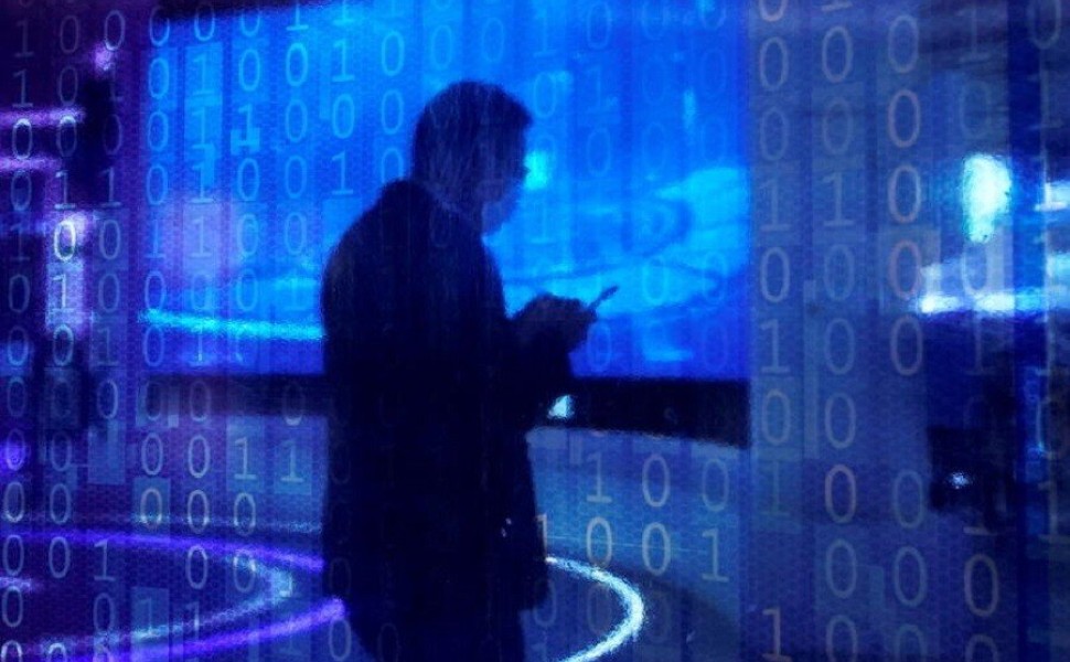 A man looking at a phone is seen through a digitally decorated glass during the World Internet Conference (WIC) in Wuzhen, Zhejiang province, China, November 23, 2020. REUTERS/Aly Song - RC2X8K922EQG